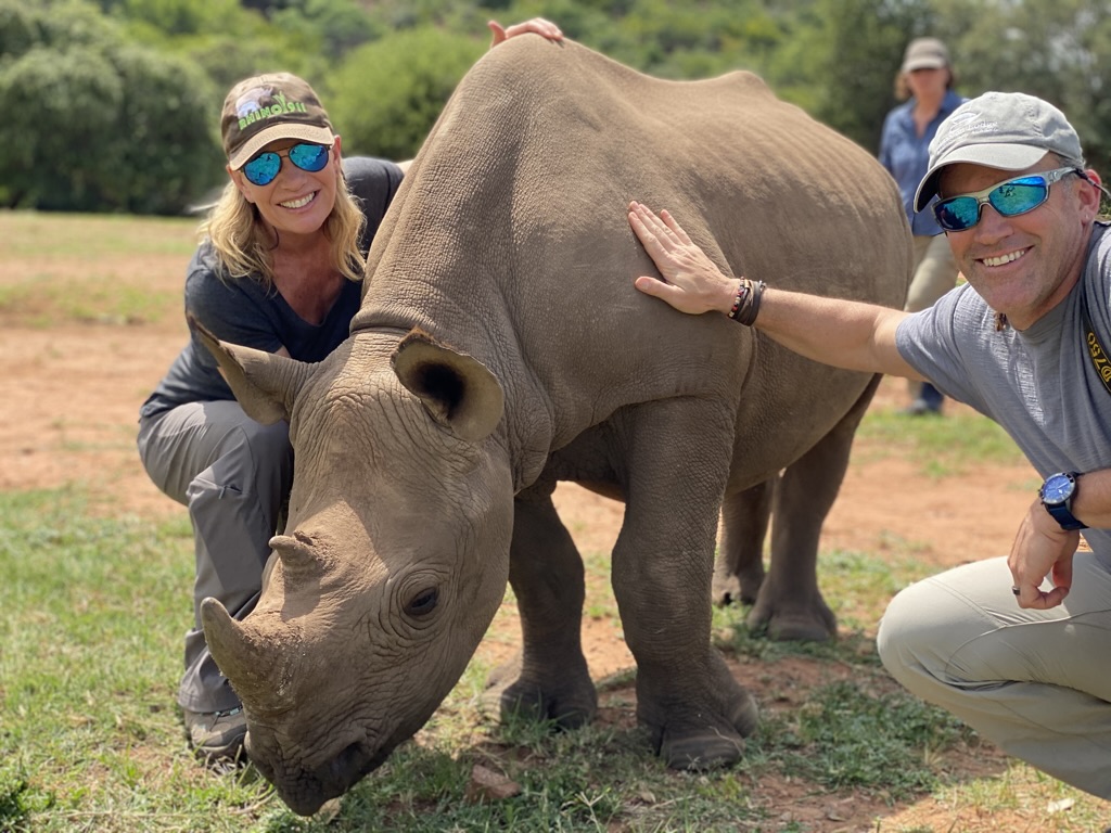 Sarah and a guide beside a young rhino during a conservation experience in South Africa